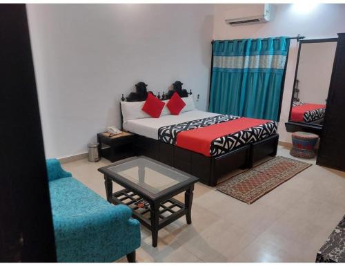 una camera con letto, tavolo e divano di Hotel Kiran Villa Palace, Bharatpur a Bharatpur
