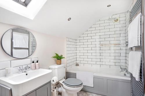 a bathroom with a sink and a toilet and a tub at Ashley Cottage in York