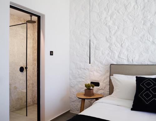 a bedroom with a bed and a glass shower at Epic Mykonos in Mikonos
