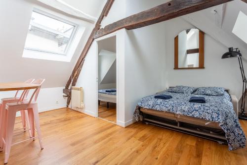 une chambre avec un lit, une table et un miroir dans l'établissement Le Marais, Romantic loft apartment! min 31 nights from June to December, à Paris