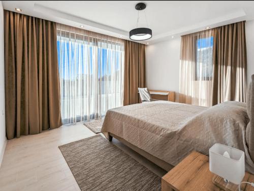 um quarto com uma cama grande e janelas grandes em Villa Elia em Utjeha