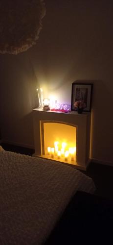 a room with a fireplace with candles in it at LIVABLŌM " Petit Dej Offert " in Guesnain