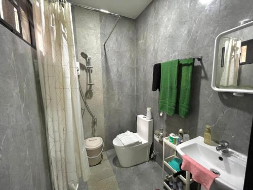 uma casa de banho com um chuveiro, um WC e um lavatório. em Studio B Loft M&K's Guesthouse em Dauis