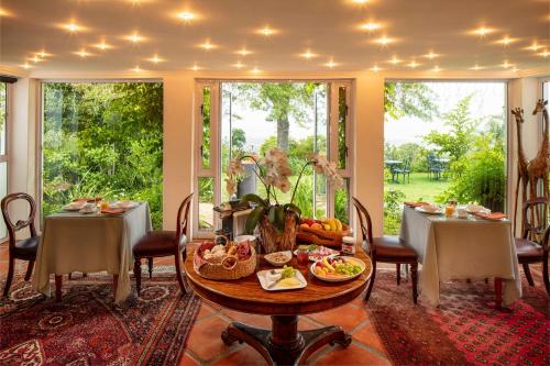una sala da pranzo con tavolo e cibo di Spanish Farm Guest Lodge by Raw Africa Collection a Somerset West