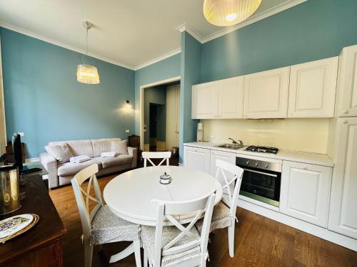 a kitchen with a white table and chairs and a couch at Suite Matteotti 133 - Sanremo in Sanremo