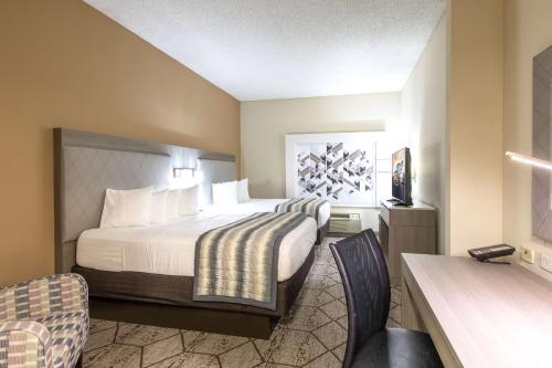 a hotel room with a bed and a desk at Wingate by Wyndham Charlotte Concord Mills/Speedway in Concord