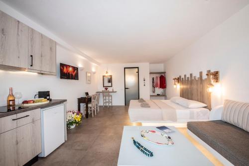 a hotel room with two beds and a kitchen at Myrsini's Luxury Suites Merchia in Mýkonos City