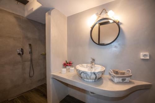 a bathroom with a sink and a mirror at Myrsini's Luxury Suites Merchia in Mikonos