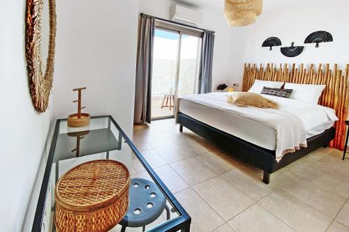 Un dormitorio con una cama y una mesa de cristal. en Caleta Blanca, en La Guirra
