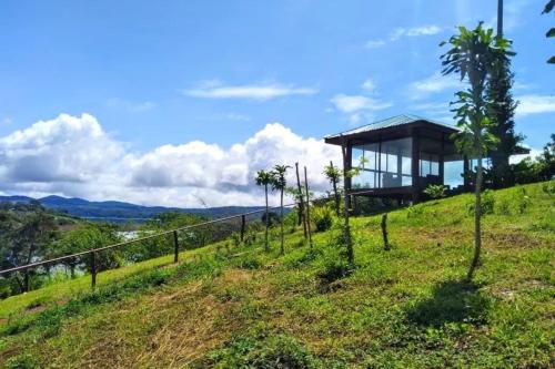 une maison en verre au sommet d'une colline dans l'établissement Amazing Villa at Lake Arenal 1, à Tronadora