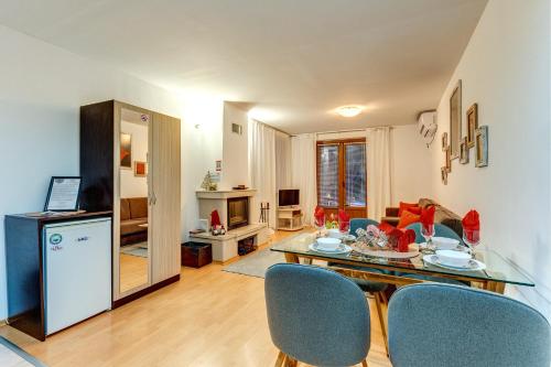 cocina y sala de estar con mesa y sillas en MyPlace Pamporovo апартаменти за отдих, en Pamporovo