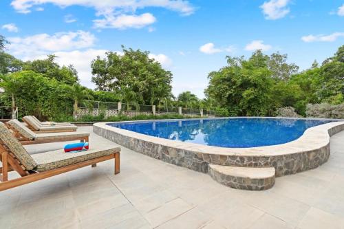 an image of a swimming pool with a stone wall around it at Outstanding & Huge 600m Private Villa - Pool - BBQ in Coco