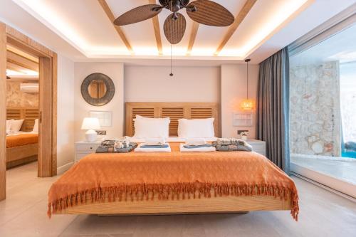 a bedroom with a large bed and a ceiling fan at Kalkan Saray Suites Hotel in Kalkan