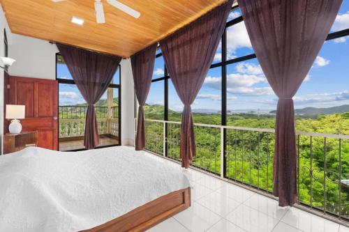 a bedroom with a bed and large windows at Amazing PenthouseL 5 min from Coco Beach in Coco