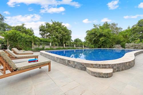 an outdoor swimming pool with a stone wall around it at Amazing PenthouseL 5 min from Coco Beach in Coco