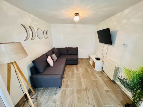 Apartamento Luna في مونغات: غرفة معيشة مع أريكة وتلفزيون بشاشة مسطحة