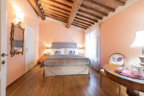 a bedroom with a bed and a table in a room at Borgo I Vicelli Adults Only Relais in Bagno a Ripoli