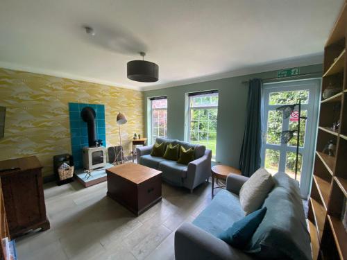 een woonkamer met een bank en een tafel bij The Whimsy 2 bedroom cottage in National Forest, private parking & garden in Blackfordby