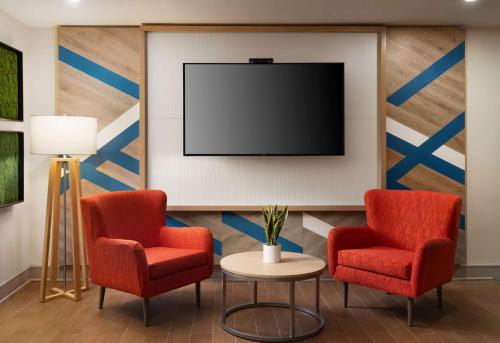 uma sala de espera com duas cadeiras e uma televisão de ecrã plano em Hilton Garden Inn Boston-Burlington em Burlington