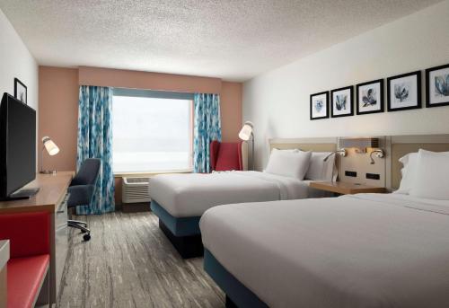 a hotel room with two beds and a television at Hilton Garden Inn Boston-Burlington in Burlington