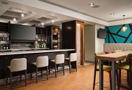 a bar in a restaurant with a table and chairs at Hilton Garden Inn Boston-Burlington in Burlington