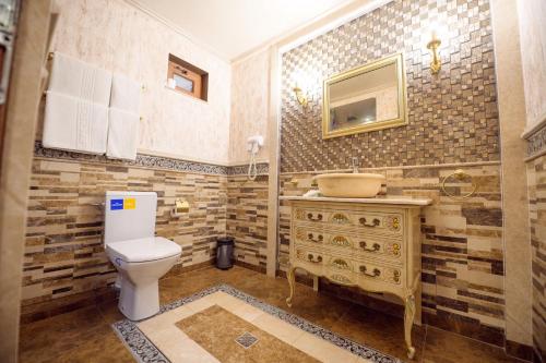 bagno con servizi igienici, lavandino e specchio di Complex Hotelier Iris-Mimoza a Jupiter