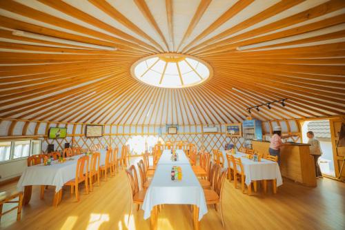 a dining room with tables and chairs and a large ceiling at Stepperiders in Ulaanbaatar