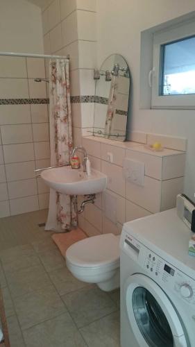ein Badezimmer mit einer Waschmaschine und einer Waschmaschine in der Unterkunft b Ferienhaus Unterfranz II b in Bad Doberan
