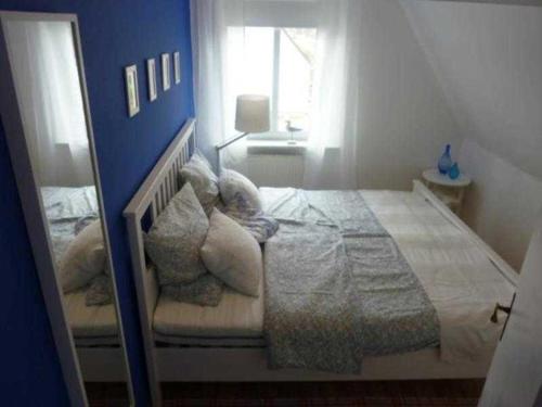 a bedroom with a large bed with a blue wall at Ferienwohnung "Kleine Sandburg" in Heiligendamm