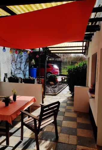 eine Terrasse mit einem Tisch und einem roten Regenschirm in der Unterkunft Ferienwohnungen Ruwoldt in Brodhagen