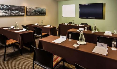a conference room with tables and chairs and a flat screen tv at Garden Court Kings Beach in Port Elizabeth