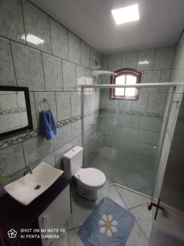 een badkamer met een douche, een toilet en een wastafel bij Casa Muro Alto-Sana Rj in Macaé