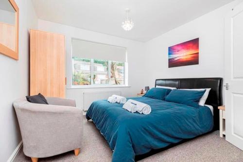 1 dormitorio con 1 cama azul y 1 silla en BOURNECOAST: CHALET BUNGALOW WITH GARDEN - HB6189, en Poole