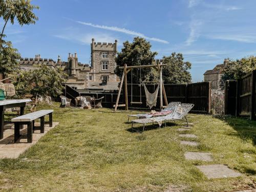a garden with a swing and a bench and a castle at East Street Beach House - luxury living by the sea in Ryde