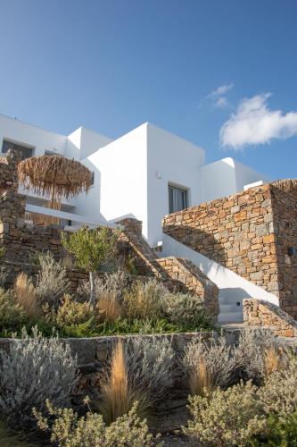 a white house with a stone wall and stairs at The Summit of Mykonos in Kalo Livadi