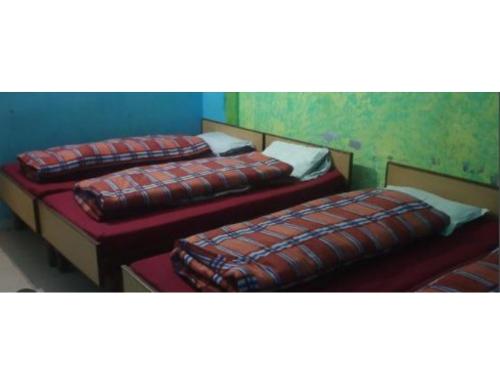 eine Gruppe von 3 Betten in einem Zimmer in der Unterkunft Gujrat Bhawan, Phata in Phata