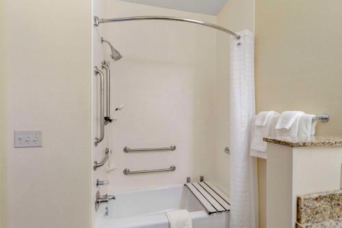 a bathroom with a shower and a bath tub at Comfort Suites Normal University area in Bloomington