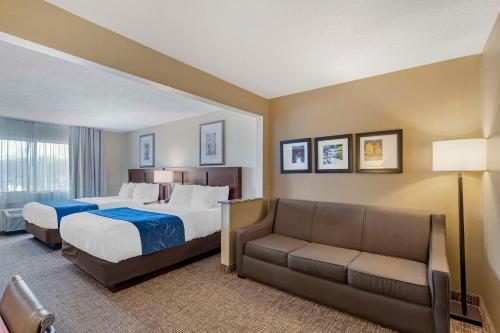 a hotel room with two beds and a couch at Comfort Suites Normal University area in Bloomington
