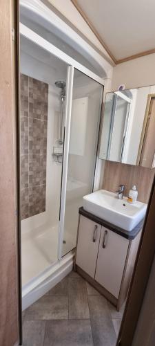 een badkamer met een wastafel en een douche bij Holiday Caravan at Beauport in Hastings
