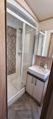 a bathroom with a sink and a shower at Holiday Caravan at Beauport in Hastings