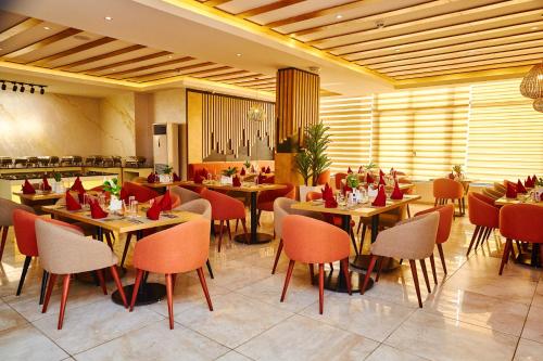 um restaurante com mesas e cadeiras num quarto em Vintano Hotel em Lekki