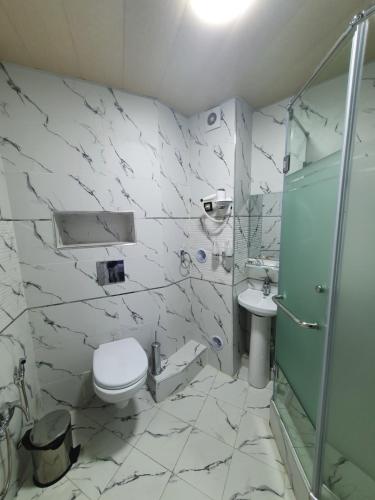 a bathroom with a toilet and a sink and a shower at Reikartz Namangan in Namangan