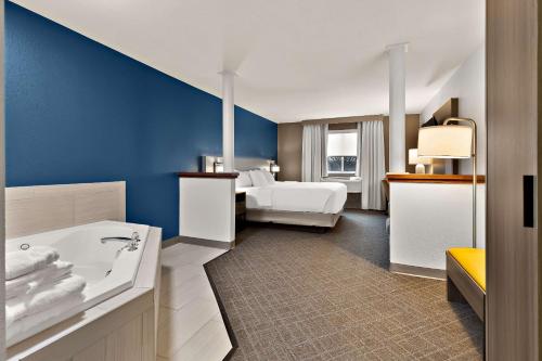 a large bathroom with a tub and a bedroom at Comfort Inn & Suites in Fremont