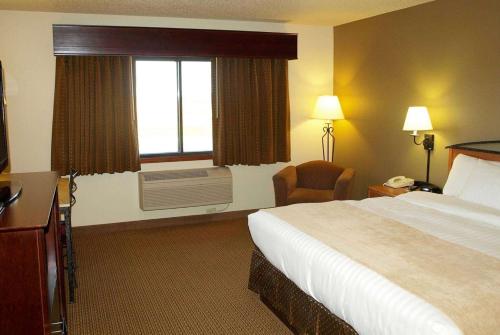 um quarto de hotel com uma cama e uma janela em AmericInn by Wyndham Grimes em Grimes