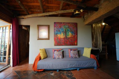a couch in a room with a painting on the wall at Rustic River & Bush Escape in Buffelspoort