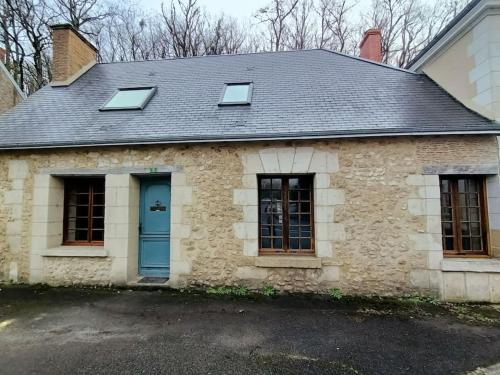 una vieja casa de piedra con una puerta azul en Gîte avec vue sur l'Indre en Artannes-sur-Indre