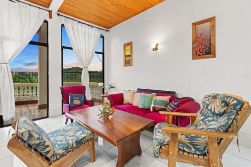 a living room with a red couch and chairs at Amazing VillaF 5 min from Coco Beach in Coco