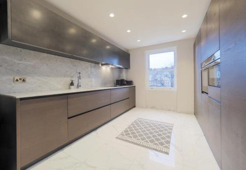 eine Küche mit einer Spüle und einer Arbeitsplatte in der Unterkunft Luxury 3 Bedroom Flat in Maida Vale in London