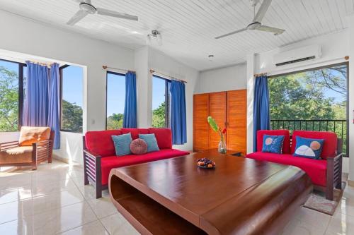 a living room with a wooden table and red chairs at Playa Negra Peaceful & Luxury Beach Dream Penthouse in Playa Negra