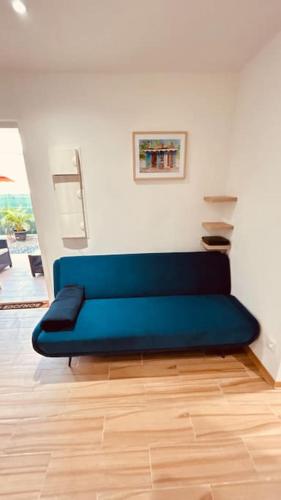 a blue couch sitting in a living room at Studio Bis Océan 2 personnes Sainte-Anne plage in Sainte-Anne